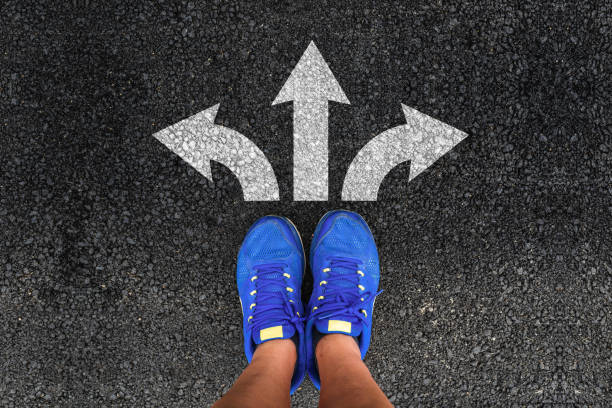 istock man legs in sneakers and three direction arrow choices 1163030446