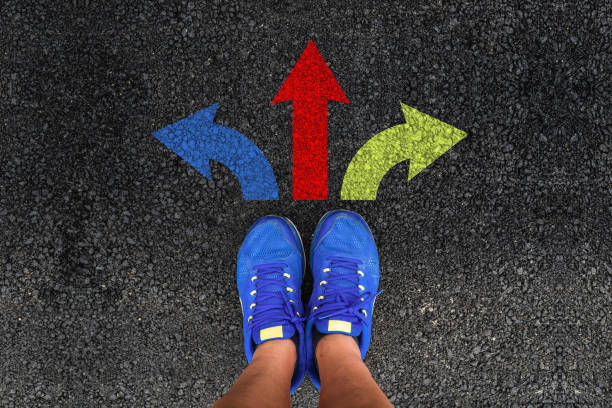 istock man legs in sneakers and three direction arrow choices 1163030468