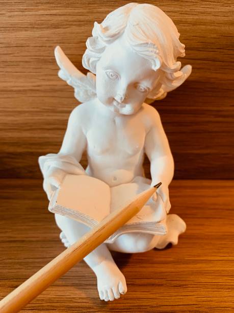 istock Reading angel on wooden background 1163031403