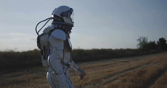 Medium long shot of man in space suit walking