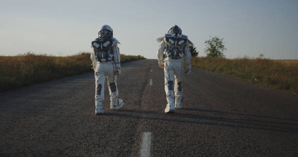 도로를 걷는 두 명의 우주비행사 - people exploration futuristic walking 뉴스 사진 이미지