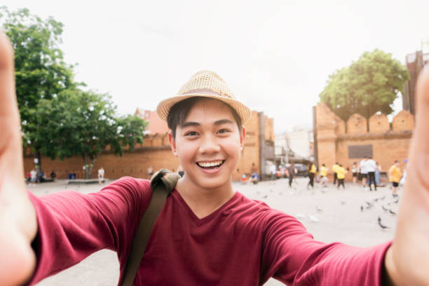 Tourists feeling and happy and fun and use a camera to take a selfie.