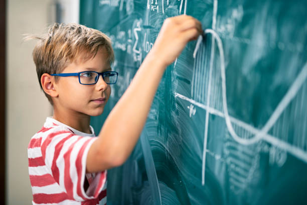 高度な数学的問題を解決する小�さな男の子 - 天才 ストックフォトと画像