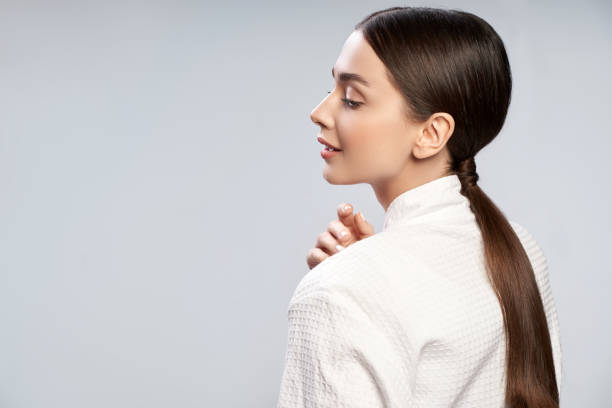 istock Charming young woman with ponytail standing against light blue background 1163035365