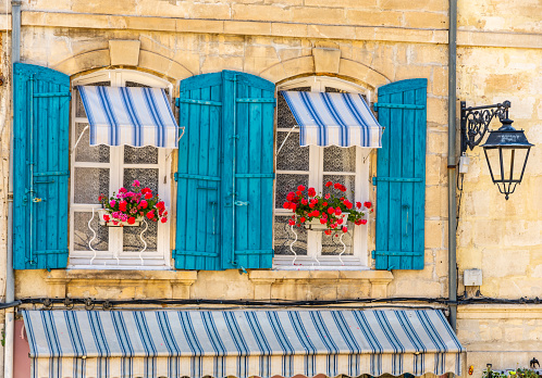 Arles, Provence-Alps-Cote d'Azur, France - June 2, 2019: View of windows with blue shutters in the historic city center.