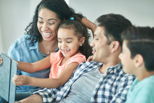 istock Mixed Race Family of Four Exploring Technology Together 1163038155