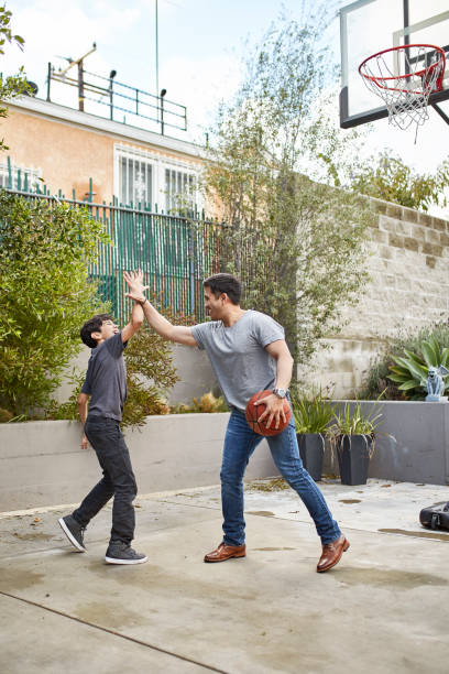 istock Athletic Hispanic Father Teaching Son Basketball Skills 1163038300