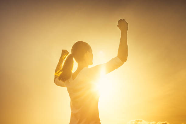 poderosa mujer fuerte flexionando contra el cielo del atardecer - human muscle women bicep girl power fotografías e imágenes de stock