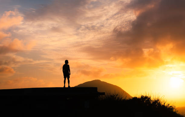 istock Man watching sunset from the mountain top 1163040295