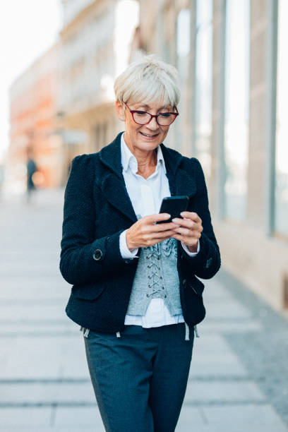 istock Senior woman texting outdoor 1163041422