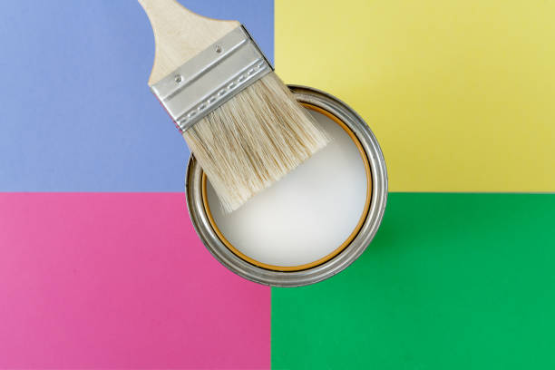 istock Brush with wooden handle and open can with white paint on colorful background. Renovation concept. Place for text. 1163043806