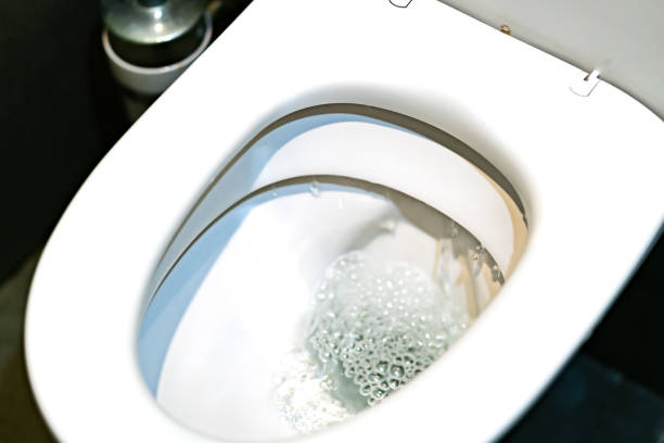 istock Toilet bowl flushing water in bathroom close up. 1163043910