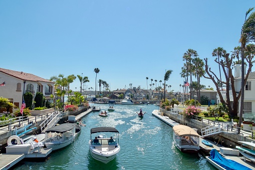 Long Beach, CA - July 14, 2018: waterway canal in the Naples Island neighborhood of Long Beach, California showing homes and people in boats enjoying a summer day