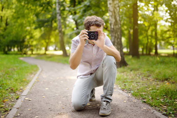istock Young man take a shot in sunny summer park. 1163045039
