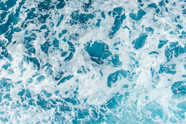 istock High angle view on the sea ocean wave foam water splash blue and white background 1163049915