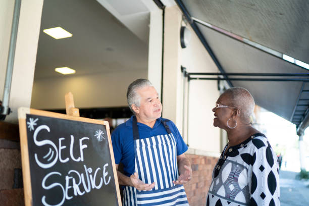 istock Restaurant owner and customer talking at entrance 1163052035