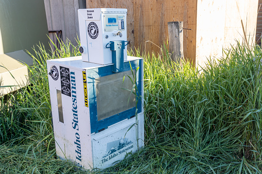 Stanley, Idaho - July 1, 2019: Vending machine for the Idaho Statesman newspaper is abandoned and empty, showing how periodicals are outdated due to advancing internet technology