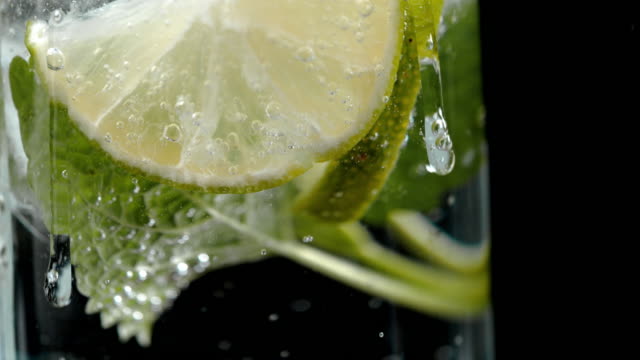 SLO MO Adding ice to a lime drink