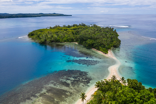 A coral reef surrounds idyllic islands off the coast of New Britain in Papua New Guinea. This area is part of the Coral Triangle due to its high marine biodiversity.