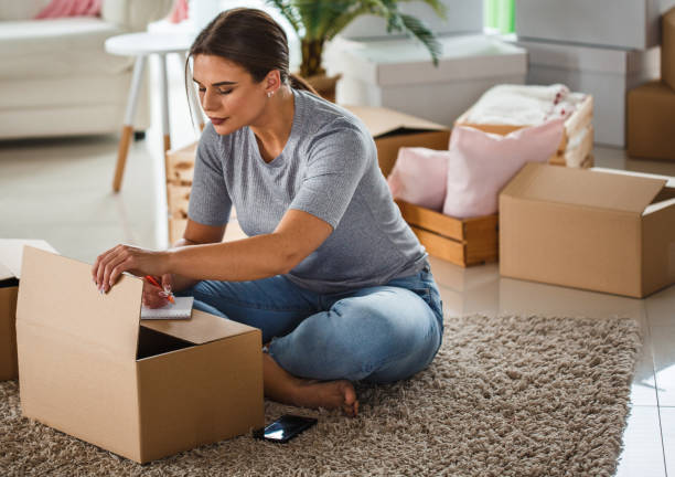 istock Woman organizing her belongings into cardboard boxes 1163060574