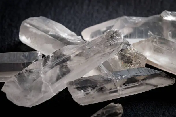 Photo of Uncut diamonds, white quartz and raw gemstones concept with a bunch of white clear minerals against a dark background