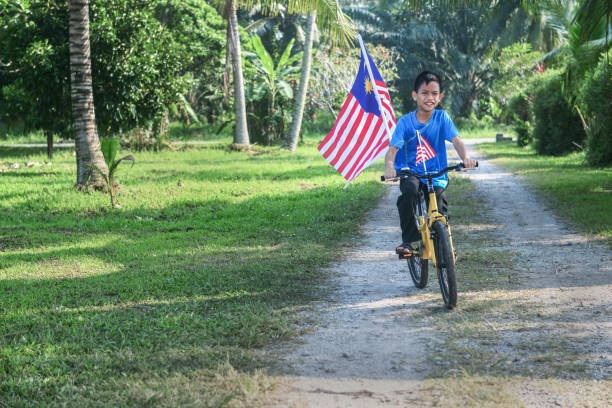 istock Happy Malaysian boy rides a bicycle during Merdeka celebration 1163076536