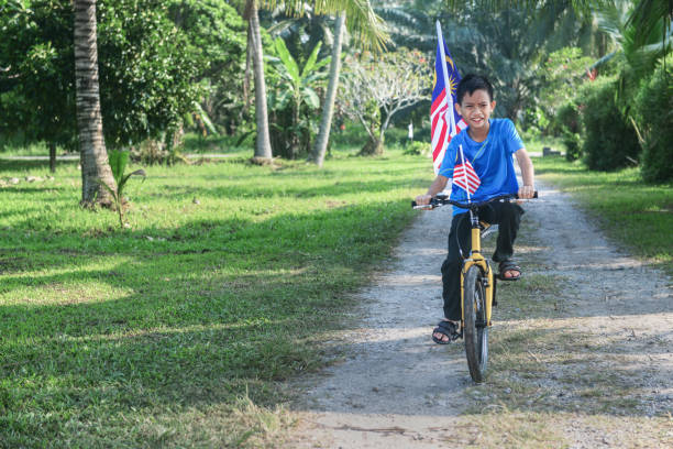 istock Happy Malaysian boy rides a bicycle during Merdeka celebration 1163076733