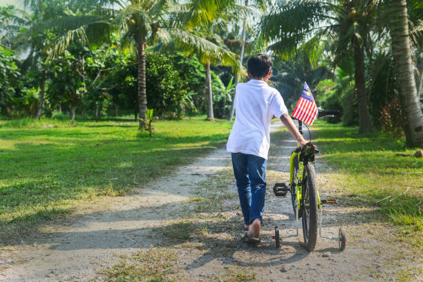 istock Malaysian boy push his bicycle during Merdeka celebration 1163078784
