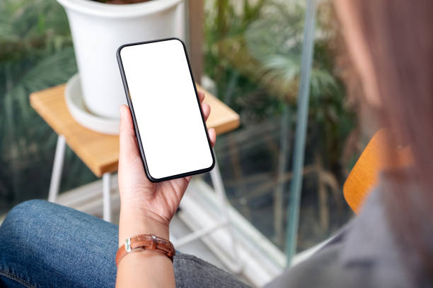 istock Mockup image of a woman holding and using black mobile phone with blank desktop screen in cafe 1163081085