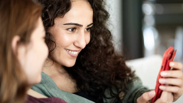 istock Young friends using mobile phone at home 1163082344