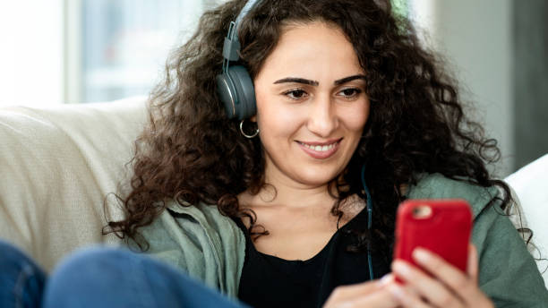 istock Young woman using mobile phone at home 1163082371