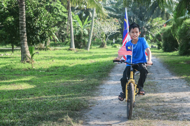 istock Happy Malaysian boy rides a bicycle during Merdeka celebration 1163083599