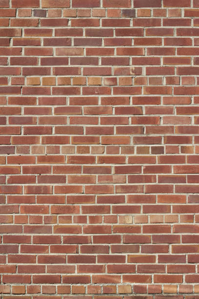 istock Old worn and grungy red clay brick wall texture background with a scorched appearance 1163083602