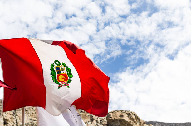 Peruvian flag , blowing in the wind with blue sky on background
