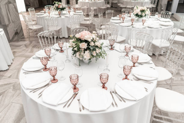 istock Round Banquet table served. Interior of restaurant for wedding dinner, ready for guests. Decorated with floral arrangement. Dishes, wine glasses and napkins. Catering concept. 1163092247