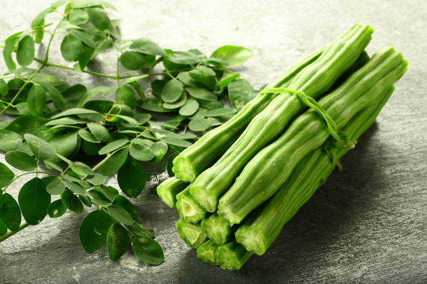 Moringa fruit and leaves Healthy vegetable- moringa fruit and leaves on vintage background moringa leaves stock pictures, royalty-free photos & images