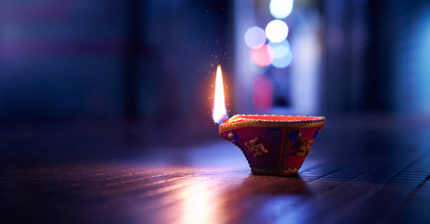 happy diwali - lit diya lampe auf der straße in der nacht - diya öllampe stock-fotos und bilder