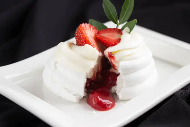Photo of Pavlova cakes  decorated fresh strawberries cracked with strawberry confiture