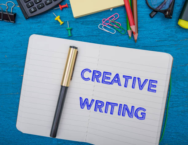 istock 'Creative Writing' Word On Note Book With Pen And Office Supplies On Blue Table 1163098440