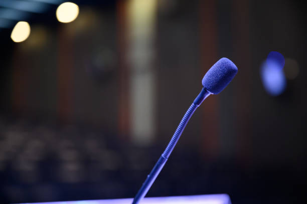 istock Microphone over the blurred business forum Meeting or Conference Room Concept, Blurred background. 1163101524