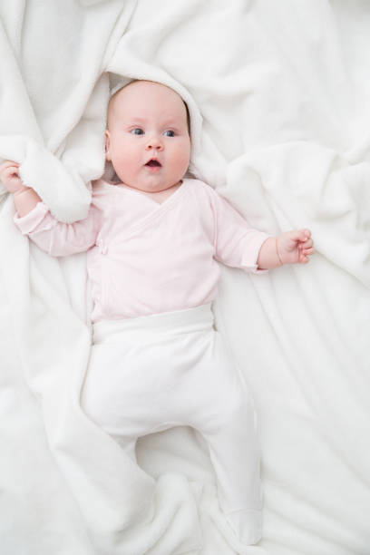 istock baby girl is lying on white blanket 1163105453