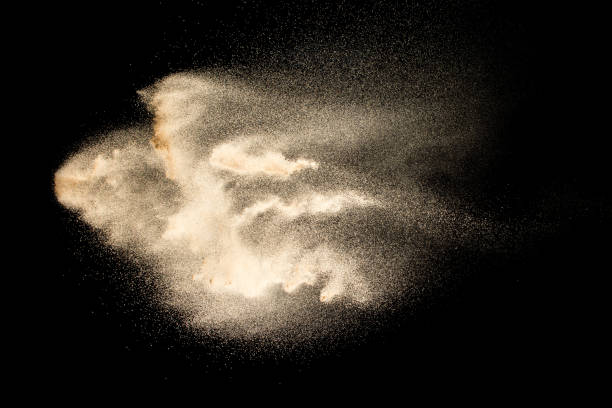 istock Abstract sand cloud.Golden colored sand splash agianst dark background.Yellow sand fly wave in the air. Sand explode on black background ,throwing freeze stop motion concept. 1163105456