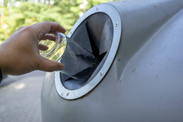 istock throwing a glass bottle to recycle container 1163105491