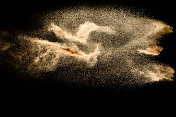 istock Abstract sand cloud.Golden colored sand splash agianst dark background.Yellow sand fly wave in the air. Sand explode on black background ,throwing freeze stop motion concept. 1163105577