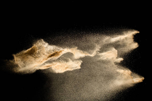 istock Abstract sand cloud.Golden colored sand splash agianst dark background.Yellow sand fly wave in the air. Sand explode on black background ,throwing freeze stop motion concept. 1163105581