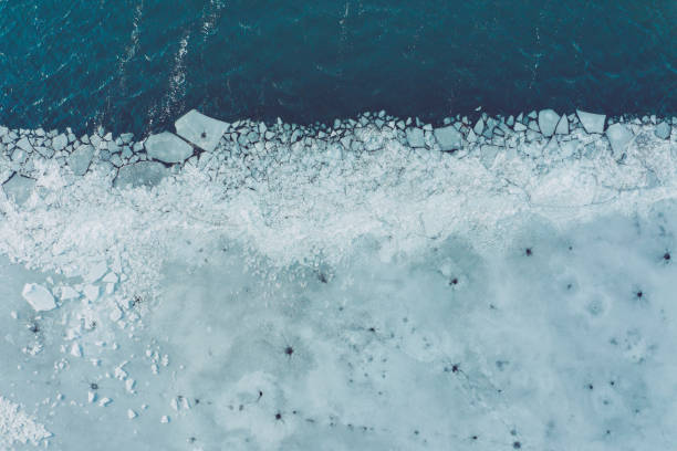Glacier Lagoon with icebergs from above. Aerial View. Cracked Ice from drone view. Background texture concept. stock photo