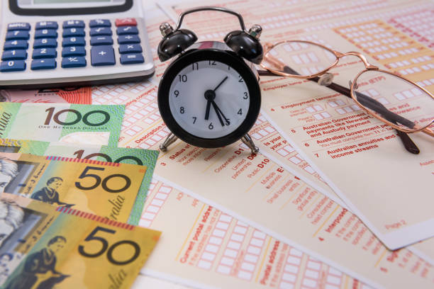 istock Australian dollars, clock and calculator on tax form 1163106693