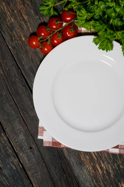 istock table setting with white plate and vegetables on wooden table, vertical 1163108447