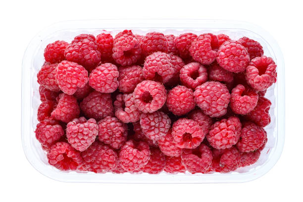 istock Fresh raspberries in a plastic tray. isolated on white background. 1163108887