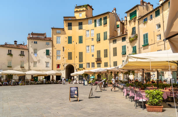 Amphitheater square with restaurants, bars and tourists in old town Lucca, Tuscany, Italy Lucca, Tuscany, Italy - July 3,2019: Amphitheater square with restaurants, bars and tourists in old town Lucca, Tuscany, Italy lucca italy stock pictures, royalty-free photos & images